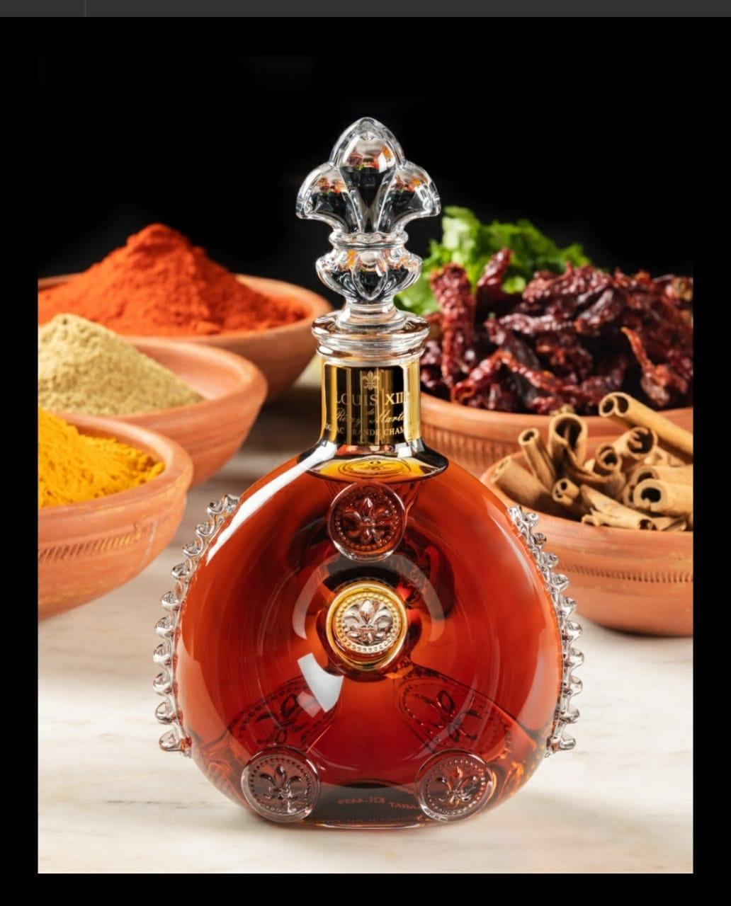 Louis XIII bottle in front of bowls of Indian spices