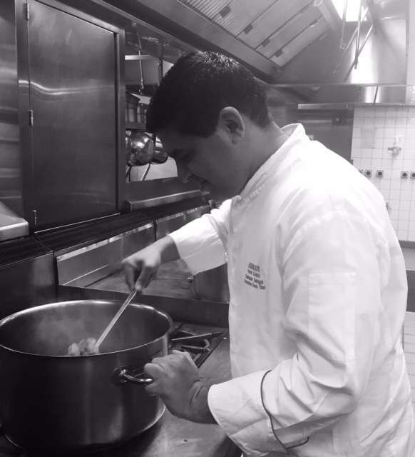 Chef Sameer Sehgal stirring a pot on the stove