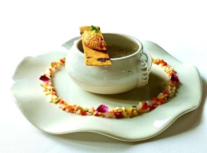 Velouté in a cup with a crisp and a ring of brunoise