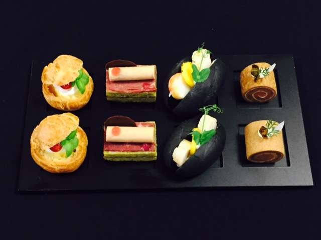 Canapé selection on a black tray