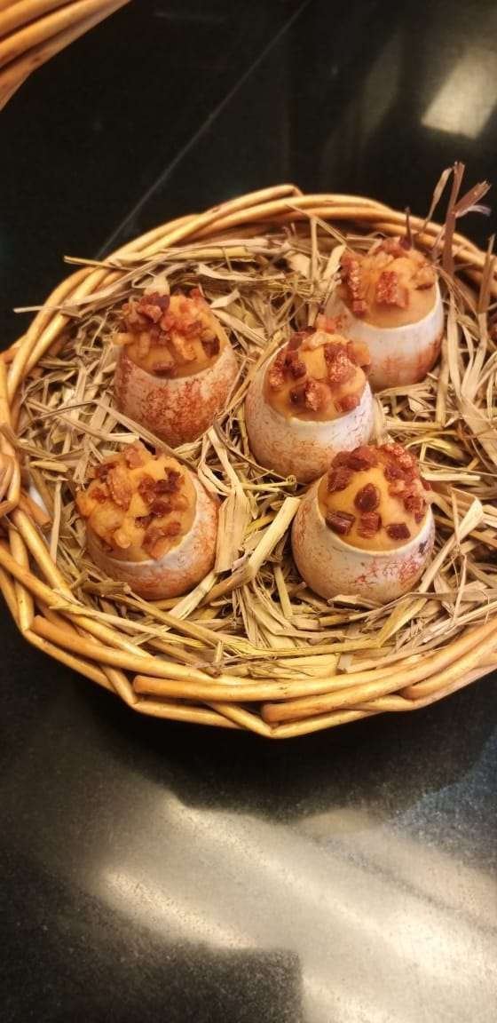 Canapés served in eggshells on a nest of straw